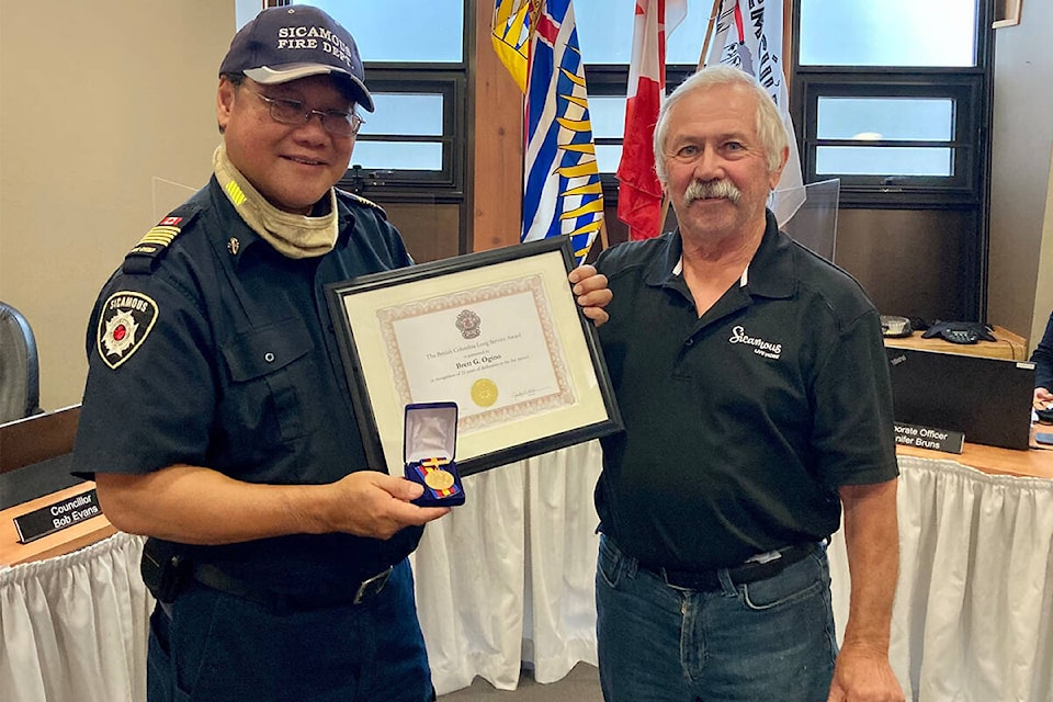 Former Sicamous Mayor Terry Rysz presents Fire Chief Brett Ogino with the B.C. Long Service Medal, in recognition of Ogino’s 25 years of fire service, on Sept. 8, 2021. (District of Sicamous image) 