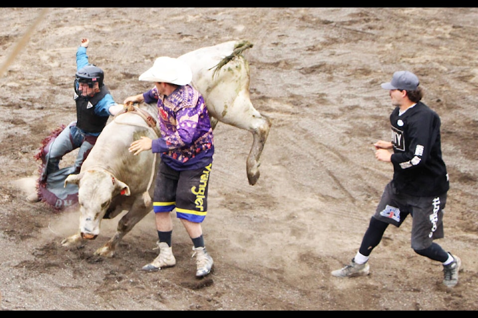 100 Mile House native and bull rider Mason Pincott grits his teeth after getting bucked by a bull with his stand still tied to its back during the 2023 Logan Parent Memorial Bullride. (Patrick Davies photo - simplymastery) 