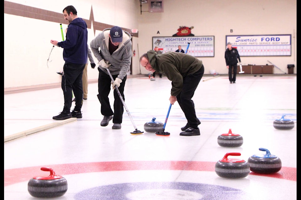 Pat Hamilton and Tom Dall put their backs into sweeping during the 100 Mile Curling Club’s 2024 Men’s Bonspiel. (Patrick Davies photo - 100 Mile Free Press) 