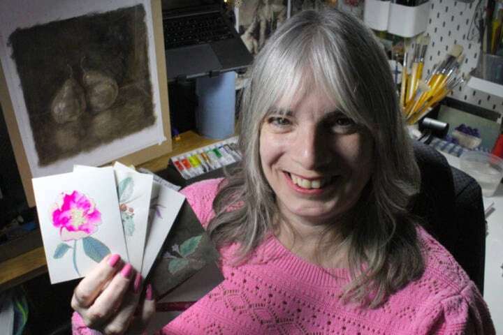 Veteran Dana Batho holding some of her prints, which are part of her collection that was sent to King Charles. (Ella Matte/News Staff) 
