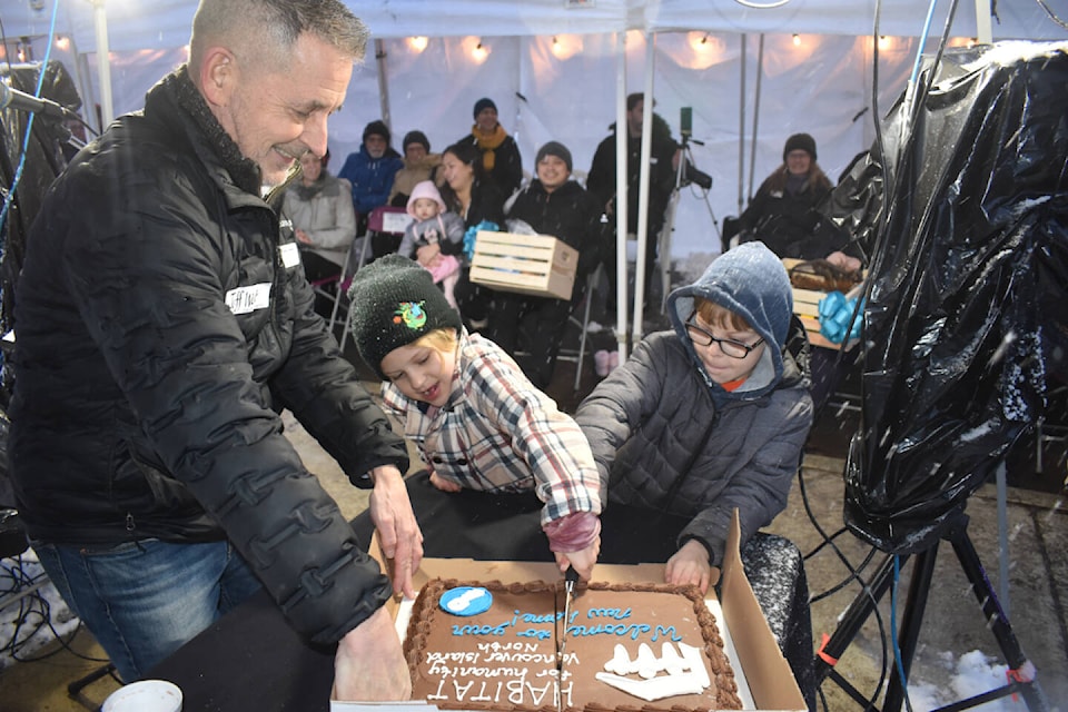 Habitat for Humanity Vancouver Island North executive director Jeff West supervises as a couple of children from the new homeowner families cut the celebratory cake as part of the key celebration for the 1375 Piercy Ave. build. Photo by Terry Farrell 
