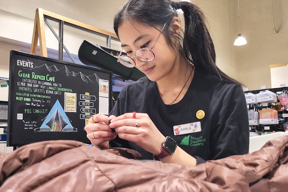 Amika Watari, KPU student and staff member at MEC, patched a jacket at the LEPS Repair Cafe on Saturday, Jan. 27. (Kyler Emerson/91ԭ Advance Times) 