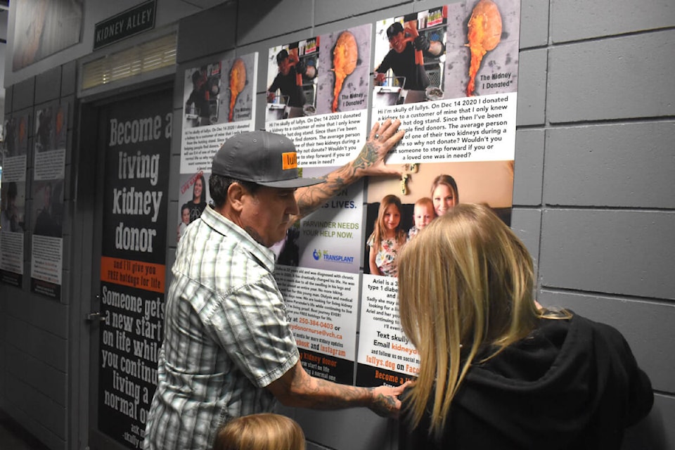 Skully White helps put up a poster of Ariel – who is in need a kidney donation – on his brand-new Kidney Alley inside the Abbotsford Centre on Tuesday (Jan. 30). (Ben Lypka/Abbotsford News) 