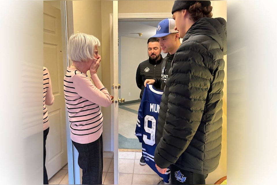 Penticton Vees co-captains Callum Arnott, left, and Thomas Pitchette, right, present fan Margaret Munro a signed jersey for her 93rd birthday. (Submitted) 