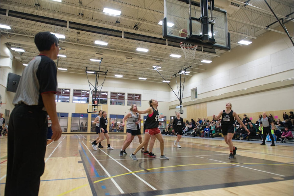 The players, referees and crowd watch in anticipation as the ball approaches the basket during the women’s division finals of the Kilrich Building Centres’ Lights Out Invitational Basketball Tournament on Jan. 28. (Dana Hatherly/Yukon News)  