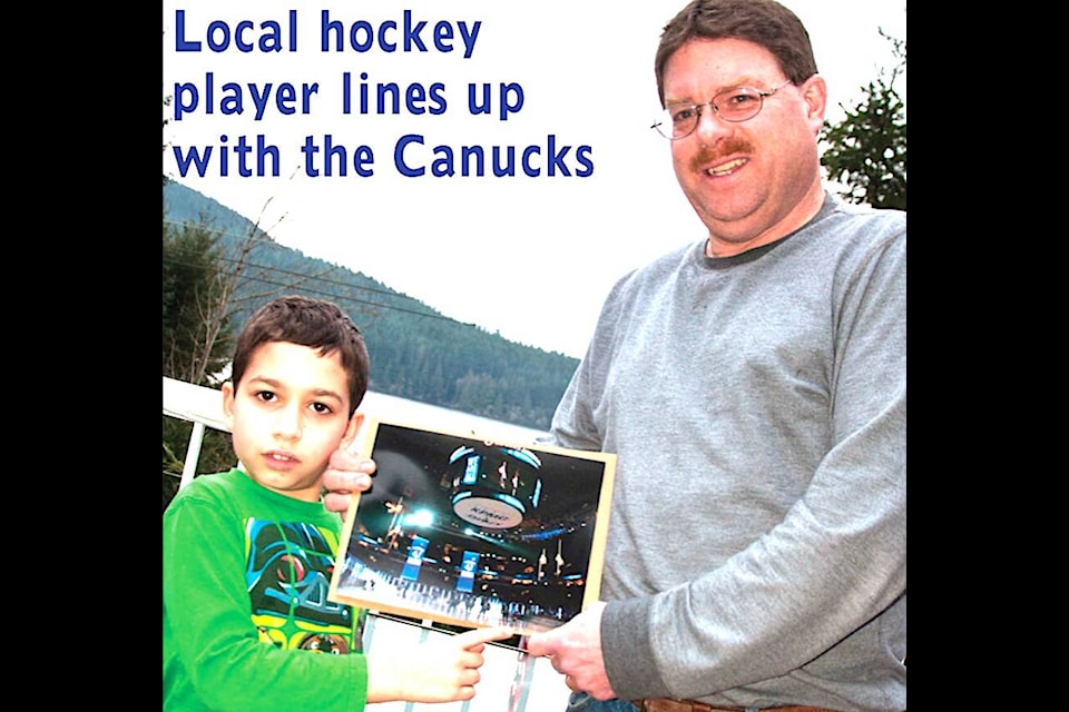 “Alex Rudzik and his father John proudly display the photo of Alex and the Canucks on ice at the pre-game ceremony of the Jan. 27 game in Vancouver.” (Lake Cowichan Gazette/Feb. 5, 2014) 