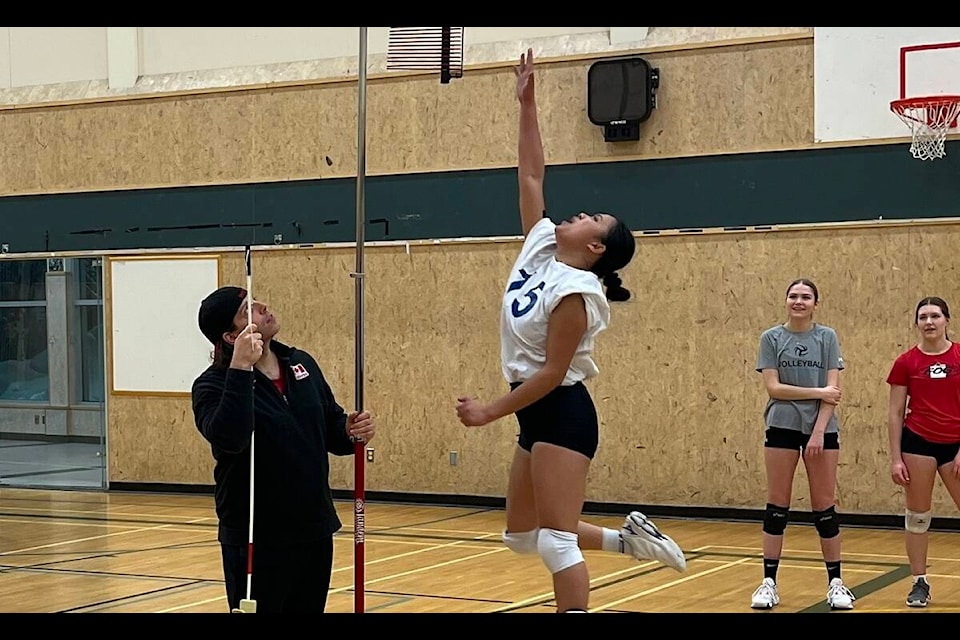 Thea Marzan, right, tries to jump as high as she can while coach Michael Cook takes note during a Volleyball Canada Combine session at St. Pat’s gymnasium on Feb. 2. Photo courtesy of Darren Horn 