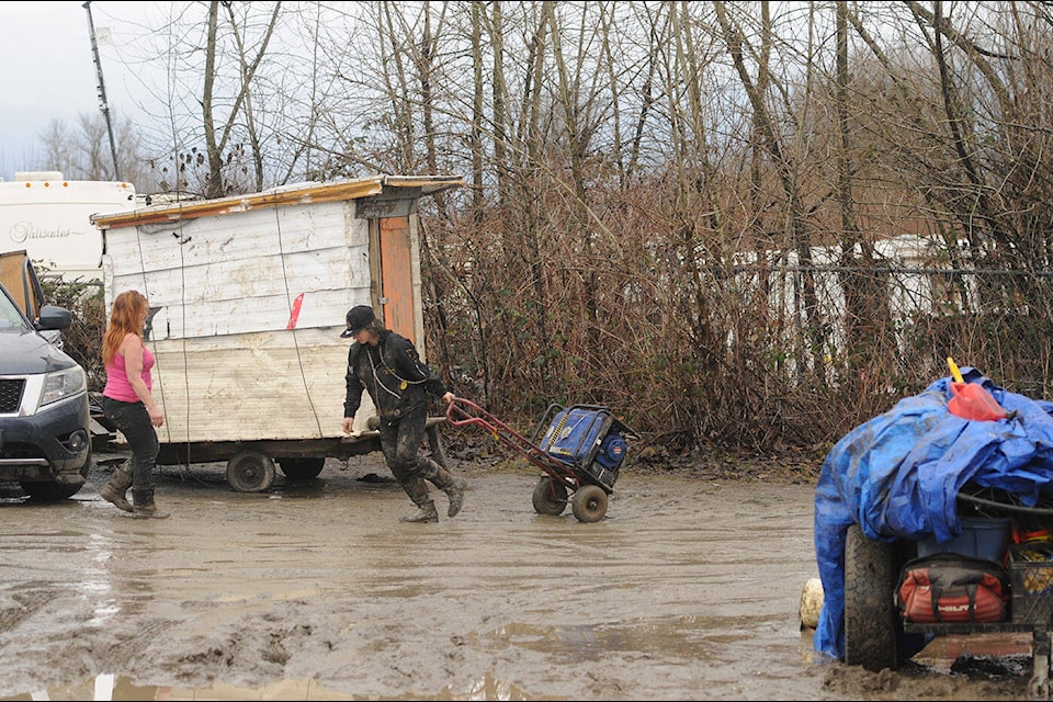 People remove items from the encampment on Island 22 on Thursday, Feb. 1, 2024. (Jenna Hauck/ Chilliwack Progress) 