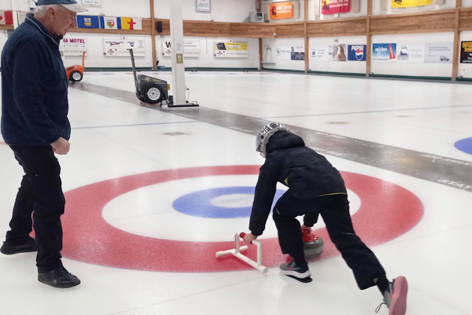 A student is instructed on how to curl at the Whitehorse Curling Club during the Polar Games on Feb. 8. (Stephanie Waddell/Yukon News) 