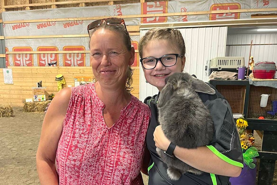 Erin Rossman (L) with Heidy Singer showing her rabbit at the District 4-H Show and Sale. (Photo by Francis Singer). 