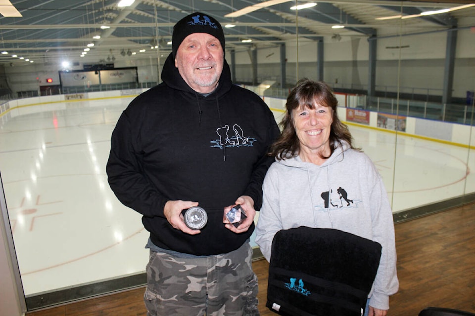 There’s mementoes aplenty at the Cowichan Valley Under 18 Memorial Hockey Tournament, as displayed by volunteers extraordinaire Dale Irving and Kristen Arnold. (Photo by Don Bodger) 