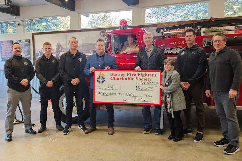 UNITI CEO Doug Tennant and advocate Lauren Simpson, along with director of development Jillian Glennie (at the wheel) accept a $100,000 donation to the Harmony apartment project from members of the Surrey Fire Firefighters Charitable Society. (Contributed photo) 