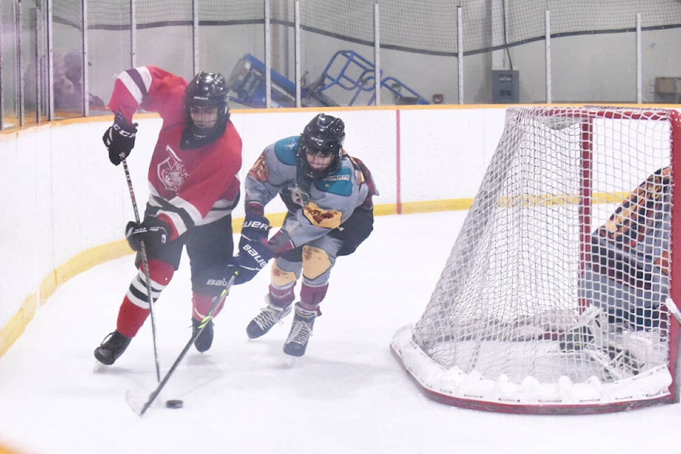 A Williams Lake Timberwolves U18 player, left, and a Kamloops Jedi player battle for the puck behind the Jedi net during a Feb. 10 tournament game in Williams Lake at the Cariboo Memorial Complex. The game was still 0-0 in period 1, with both teams working to get on the score board. (Ruth Lloyd photo - Williams Lake) 