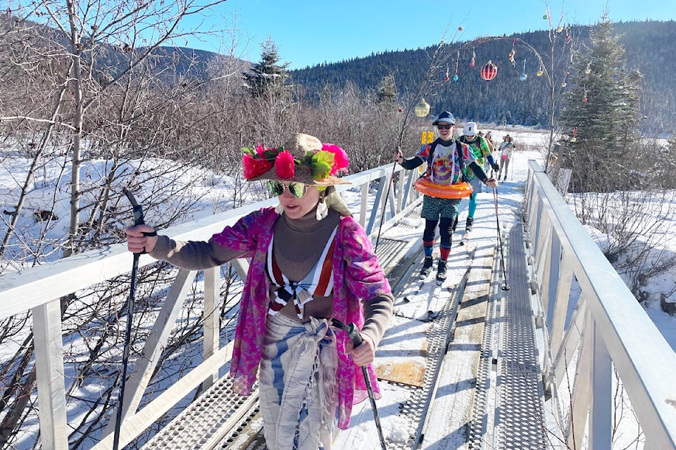 Ten Williams Lake beach bums make their way through the 2024 Wells Gourmet Ski Tour on Feb. 17. The one spot where snow was insufficient was a bridge, where boards safely provided passage for skis. (Ruth Lloyd photo - Williams Lake Tribune) 