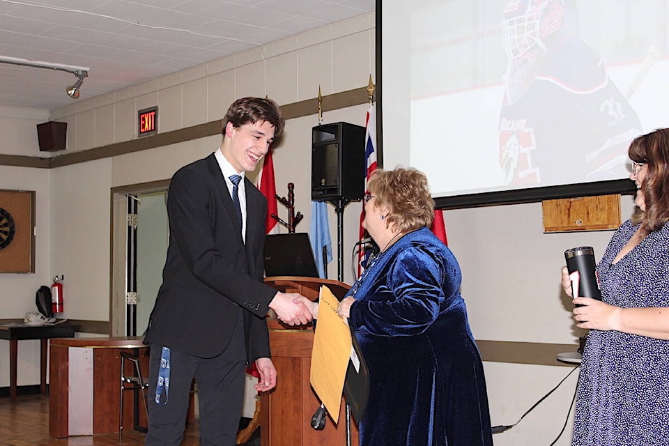 In fun awards given out to the Sicamous Eagles, Ezra Chan accepts the “Cool Headed Award for when he was alone on the bench after Coach Nick was ejected” from team governor Sheila Devost at an awards night held on Sunday, Feb. 18. (Heather Black-Eagle Valley News) 
