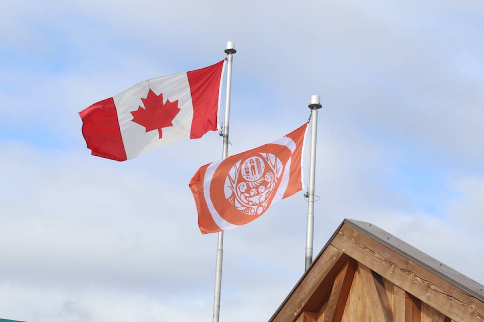 The Canadian flag and Truth and Reconciliation flag fly at Dutch Lake Community Centre on Sept. 28, 2023 (Photo by Zephram Tino) 