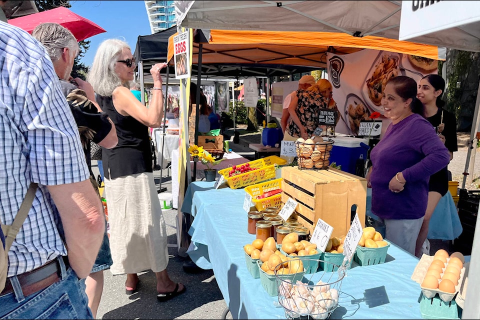 Pav and Gurpreet GIll, right, were busy selling fresh eggs and goods from their aunt, Harpreet Nagra, during a previous season’s market. (Tricia Weel photo) 