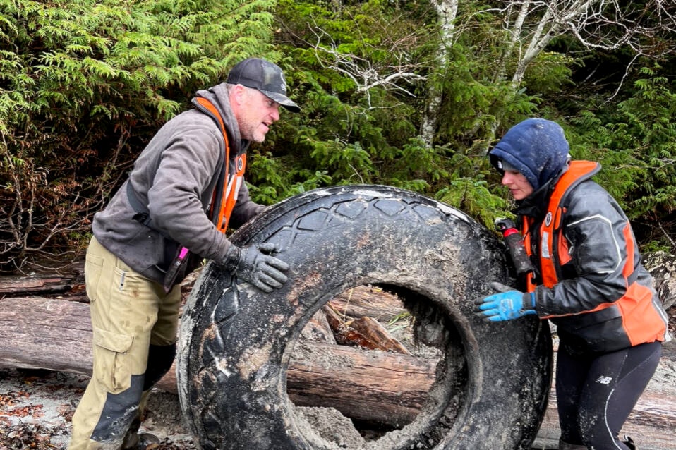 Josh Grin and Laura Gly, a boat operator for various tour operations, move a tire during the clean up. (Submitted photo) 
