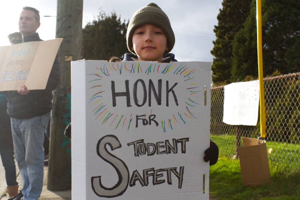 Grade 4 Thomas was amongst one of the dozen at the rally for school liaison officers to return to Greater Victoria schools. (Ella Matte/News Staff) 
