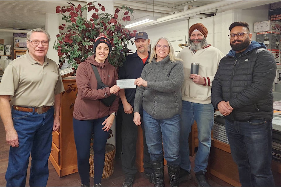 Angie Johnson, second from left, of the Cariboo Chilcotin Gymnastics Association, accepts a cheque from Deborah Pickering, centre, Operation Red Nose Coordinator, alongside other Citizens on Patrol volunteers Ric Northcott, left, Neil Sukert, Bob Sunner and Ramandeep Singh volunteers. (Photo submitted) 