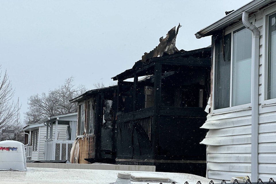 A fire heavily damaged a three-plex and destroyed two vehicles near the corner of Bernard Avenue and Burtch Road on Mon. Mar. 4, 2024. The Kelowna Fire Department says the blaze is suspicious. (Brittany Webster/Capital News) 