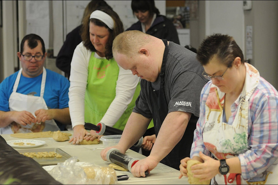 From left, Kyle McMillan, vocational councillor Jodie Dessau, Alec Chelczynski, and Kara-Lyn Loewen with Chilliwack Society for Community Living make Tommy㽶Ƶֱs Choice Dog Cookies on Feb. 21, 2024. (Jenna Hauck/ Chilliwack Progress) 