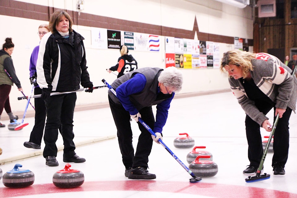 100 Mile House’s Debbie Barker sweeps the ice to help her team’s rock enter the house during the 2024 100 Mile Curling Club’s Ladies Bonspiel. (Patrick Davies photo - 100 Mile Free Press) 