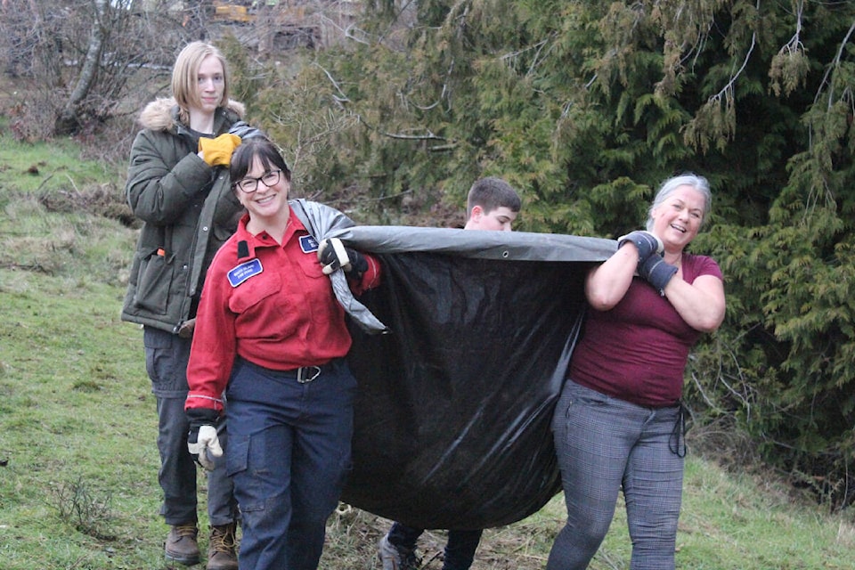 BC WildFire Service’s Susan Eliuk helps Belmont Secondary students haul invasive plants to the wood chipper. (Mark Page/News Staff) 