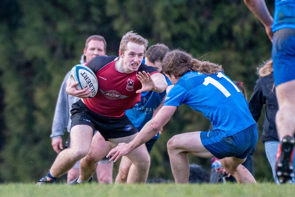 Winger Dylan Cooper - playing his first senior men’s game - prepares to stiff-arm a Nanaimo defender. Lorne Collicutt photo 