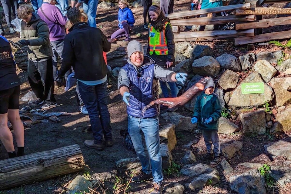 About 70 people toss thawed salmon carcasses into Douglas Creek during the annual PKOLS-Mount Douglas Conservancy event to return nutritions to the Saanich waterway. (Courtesy PKOLS-Mount Douglas Conservancy) 