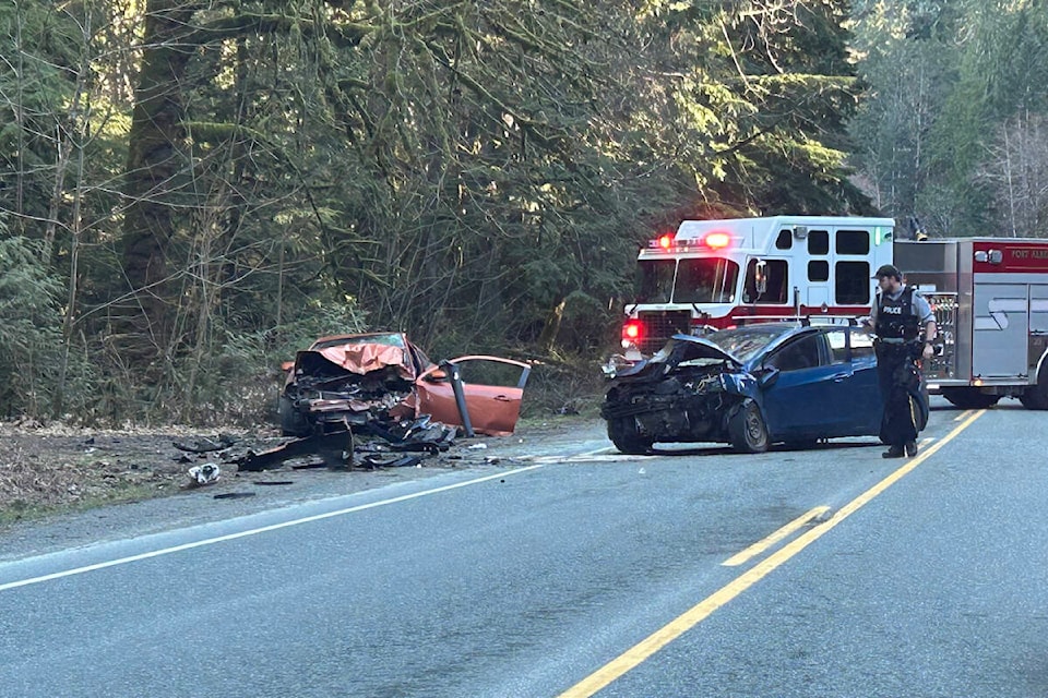An RCMP officer surveys the damage following a head-on collision on Highway 4 west of Cathedral Grove on Saturday, March 16, 2024. (CYRIL RODGERS PHOTO) 