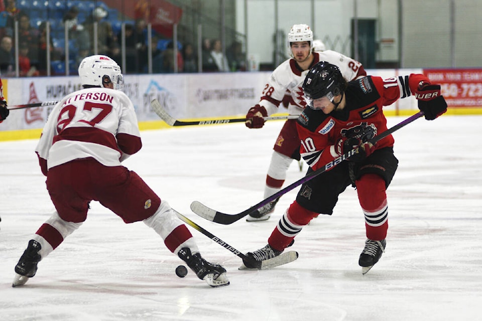 Alberni Valley Bulldogs’ winter Hayden Stavroff, right, knocks the puck past Chilliwack Chiefs’ defenceman Trey Patterson on a third-period drive to the Chiefs’ net, Friday, March 22, 2024 during a B.C. Hockey League game at the Alberni Valley Multiplex. (SUSIE QUINN/ Alberni Valley News) 