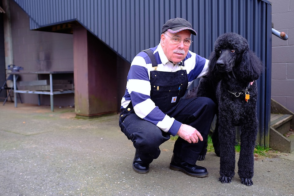 Ross Lane, 76, was diagnosed with Parkinson’s disease in early 2023. He poses beside Jet, his 12-year-old black poodle. (Olivier Laurin / Comox Valley Record) 