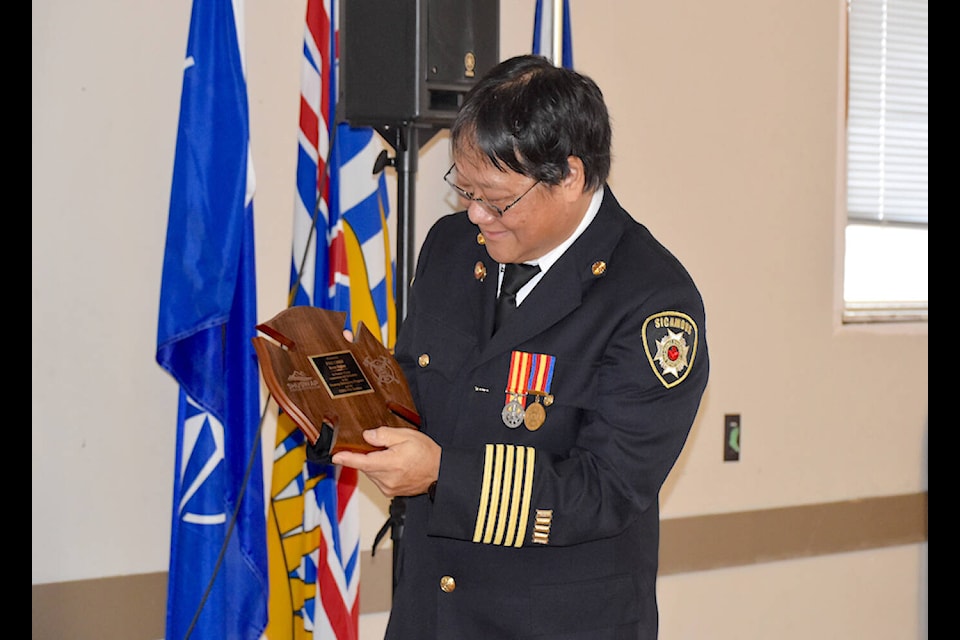 Sicamous fire Chief Brett Ogino, retiring after 28 years with the department, takes a closer look at the plaque presented to him at a party in his honour on Tuesday, March 19 at the legion. (Heather Black-Eagle Valley News) 