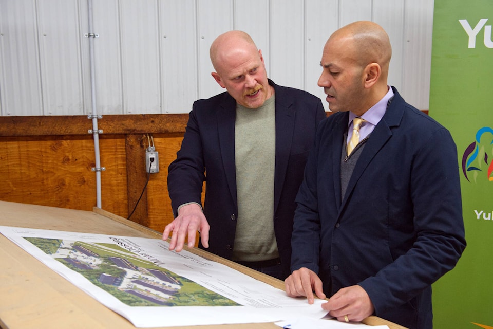 Premier Ranj Pillai examines plans for the new Winter Crossing housing project alongside Ben Asquith, the CEO of Da Daghay Development Corporation, on Feb. 28 in Whitehorse. (Matthew Bossons/Yukon News) 