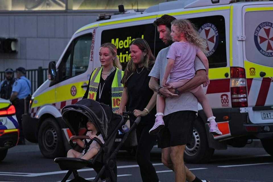People are led out from the Westfield Shopping Centre where multiple people were stabbed in Sydney, Saturday, April 13, 2024. (AP Photo/Rick Rycroft) 