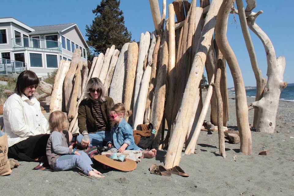 Cait Laing and Cate Webb spend some time at Cordova Bay beach with their kids. Luckily prior beachgoer built the perfect windshield to enjoy the sunny, but breezy April day. (Christine van Reeuwyk/News Staff) 