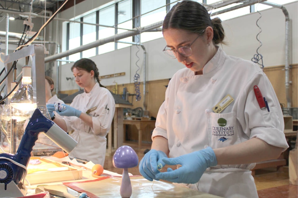 Megan Strand of Vancouver Island University’s professional baking and pastry arts program pulls sugar at the trades and tech showcase at Nanaimo on Saturday, April 6. (Karl Yu/News Bulletin) 