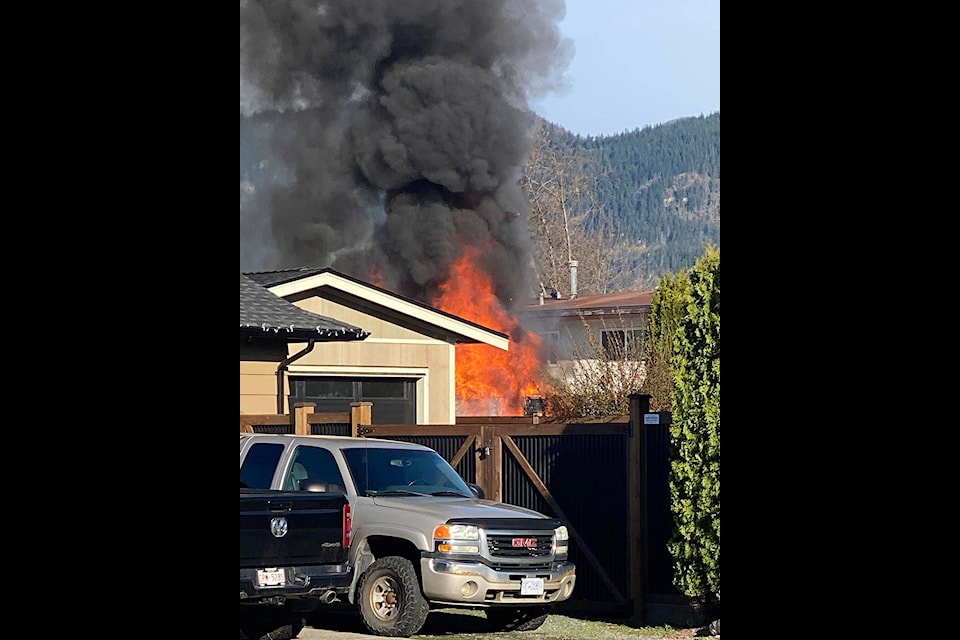Flames and smoke are seen from a travel trailer that caught fire on Elgin Drive on Saturday, March 30, 2024 in Chilliwack. (Trina Schols) 