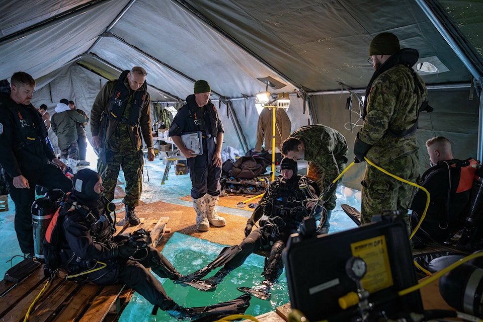 Divers from the Royal Canadian Navy, Canadian Army, the French Army and the Belgian Army prepare to dive under ice in order to demonstrate skills and competency, along with interoperability between nations during Operation NANOOK-NUNALIVUT in Yellowknife on March 9. Photo courtesy of Combat Camera/Canadian Armed Forces 