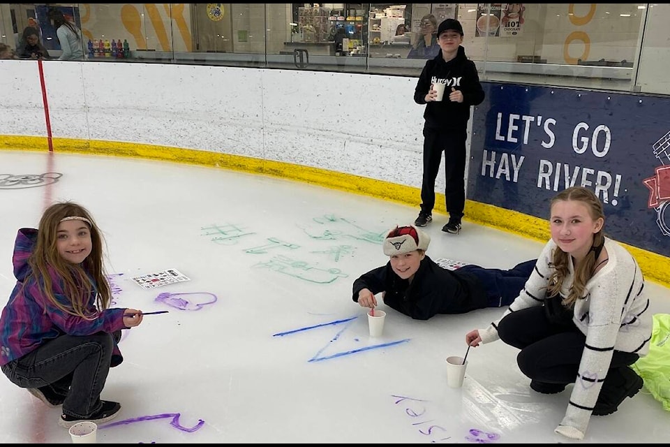 Some of the participants in Hay River’s Paint The Ice decorate the surface on March 26, the day before the lce was melted down for the season. In front from left are Oakleigh Fraser, Nash Fraser and Paisley Fraser; standing in back is McCoy Fraser. Photo courtesy of Courtney Fraser 
