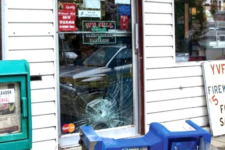 “(Bottom right) Store owner Rose Steven talks to Cst. Grant Desmet in the immediate aftermath of the armed robbery at Shop and Save in Youbou this past Saturday. (Above) A newspaper box is left fallen by the store’s door, which is also smashed, with witnesses saying the suspect kicked the door open and the box over in an attempted escape with the money.” (Lake Cowichan Gazette/April 9, 2014) 