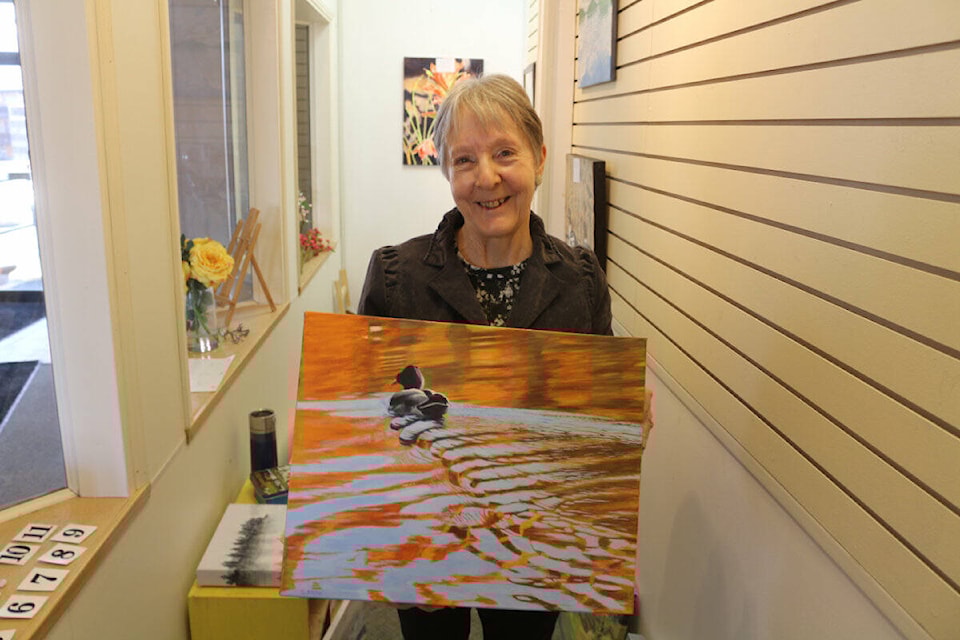 Susan Kruse holds up <em>Evening Mallard</em> her acrylic painting based on Sheridan Lake.3 (Misha Mustaqeem photo - simplymastery) 