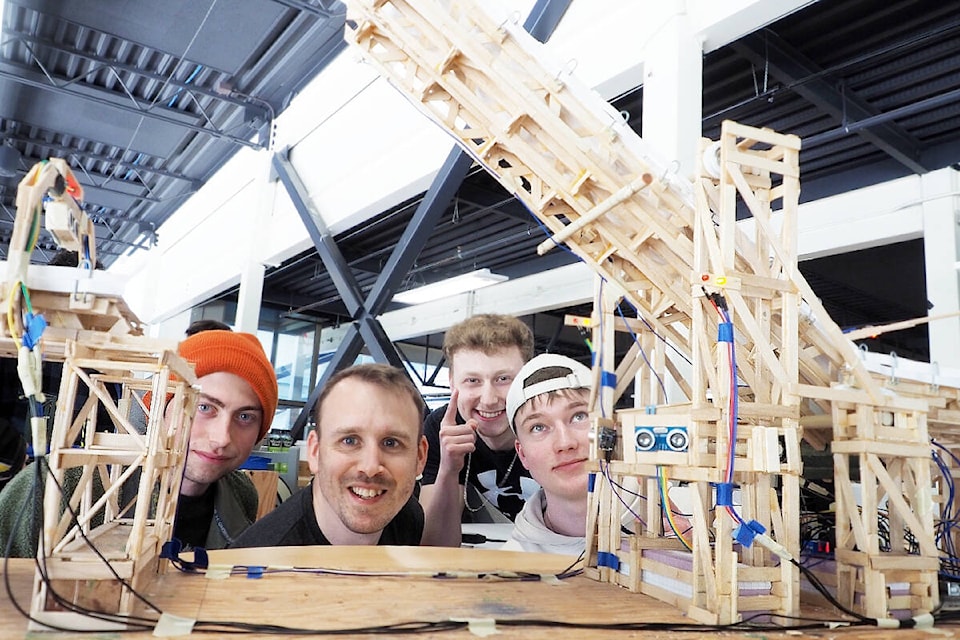 VIU first year engineering design students Cam Le Patourel, left, Micheal Gallo, Owen Giles and Robin Stephan pose for a shot with their single leaf Bascule type bridge during a public exhibit of designs by several engineering design teams Friday, April 12. (Chris Bush/News Bulletin) 