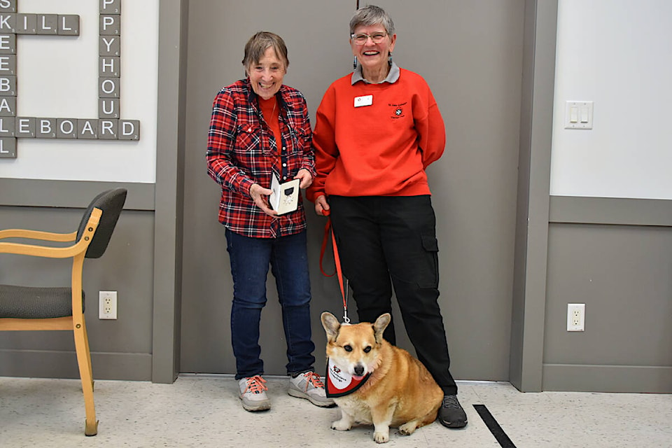 Joyce Polley, left, who logged 8,740 volunteer hours as facilitator of the St. John Ambulance dog therapy program, celebrates her Order of St. John recognition with the new director Gail Viens and therapy corgi Sam at Shuswap Lodge on Tuesday, April. 9. (Heather Black-Salmon Arm Observer) 
