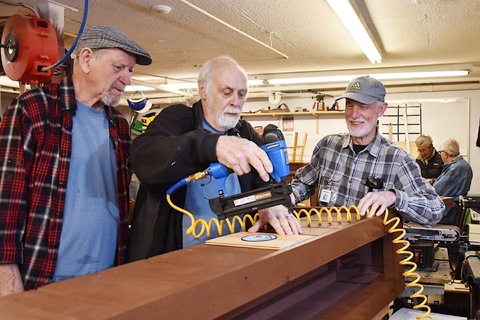 Wayne Reimer, left, Gilbert Durant, center, and Les Hall, put the finishing touches on a planter made from recycled cedar fence boards. (Colleen Flanagan/The News) 