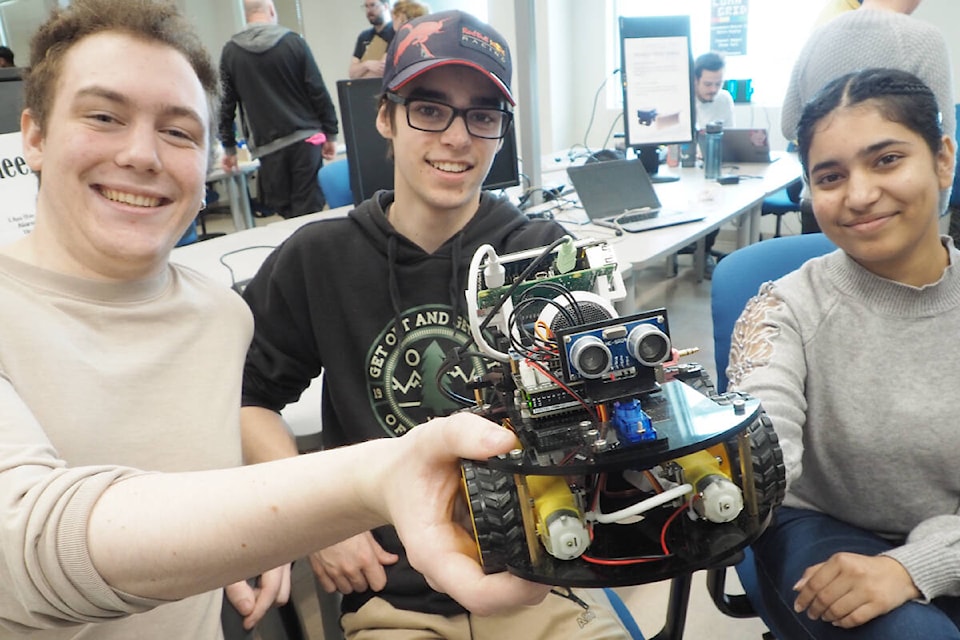 Matthias De Gisi, left, Tye Fleming and Riye Parmar crafted Wake Wheel, an alarm that flees when its alarm goes off, forcing its user to chase it to shut it off. (Chris Bush/News Bulletin) 