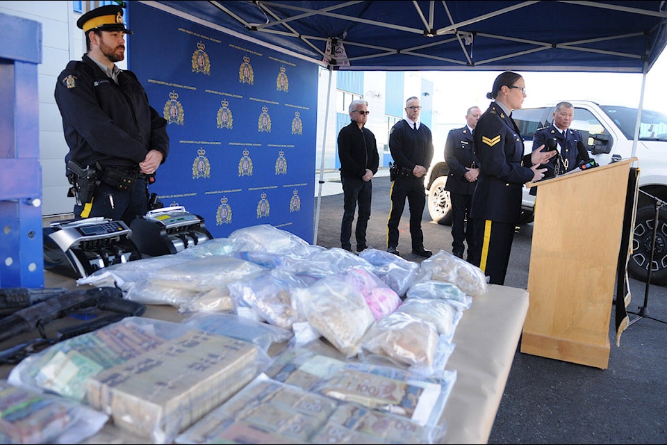 Cpl. Carmen Kiener speaks during a press conference in Chilliwack on Wednesday, April 17, 2024. Pictured here are some of the items seized from a large drug bust including $500,000 in cash, $5 million in street drugs, and $300,000 in vehicles. (Jenna Hauck/ Chilliwack Progress) 