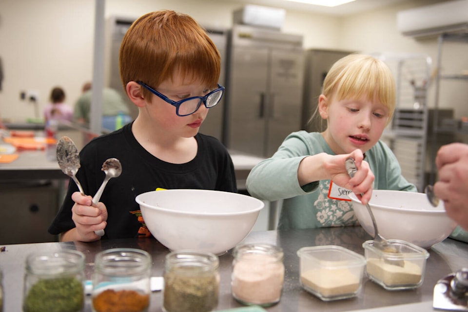 Callum and Sierra season their mashed black beans to taste for their tostadas during a Little Chefs class at Zest Commercial Food Hub on Tuesday, April 9, 2024. (Lachlan Labere-Salmon Arm Observer) 