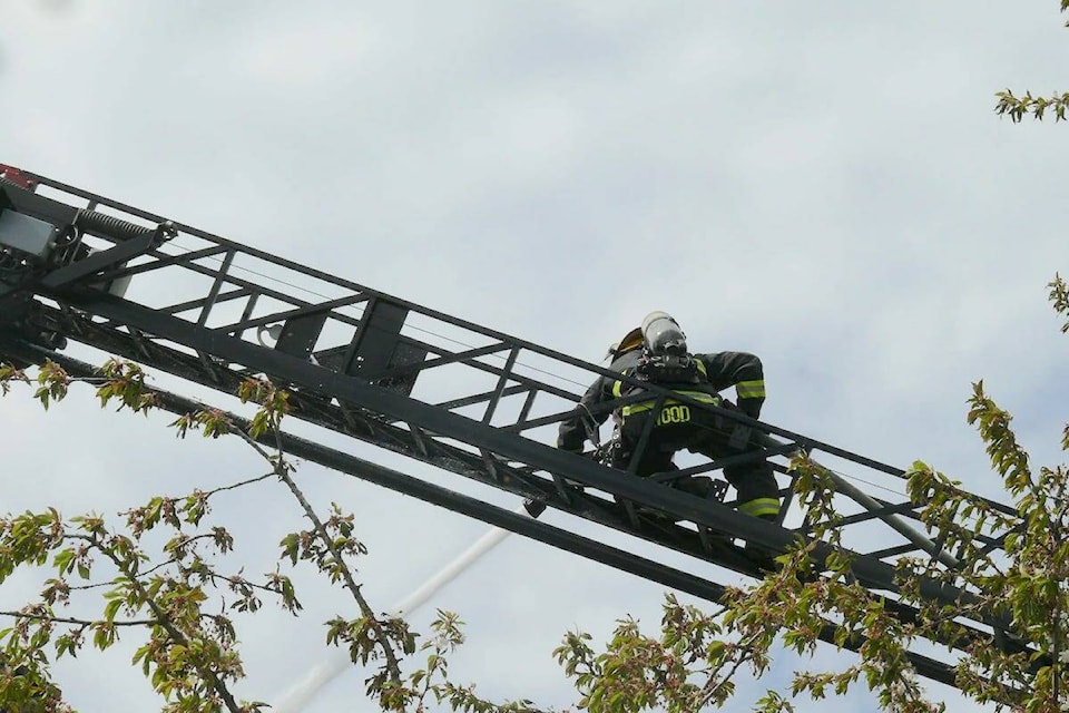 A firefighter hosed down the smouldering remains of a fire after three people were taken to hospital, two for treatment of minor burns and one for smoke inhalation suffered trying to put out a fire that damaged four houses in Aldergrove Saturday morning in the area of Davis Crescent and Springfield Drive. (Dan Ferguson/Langley Advance Times) 